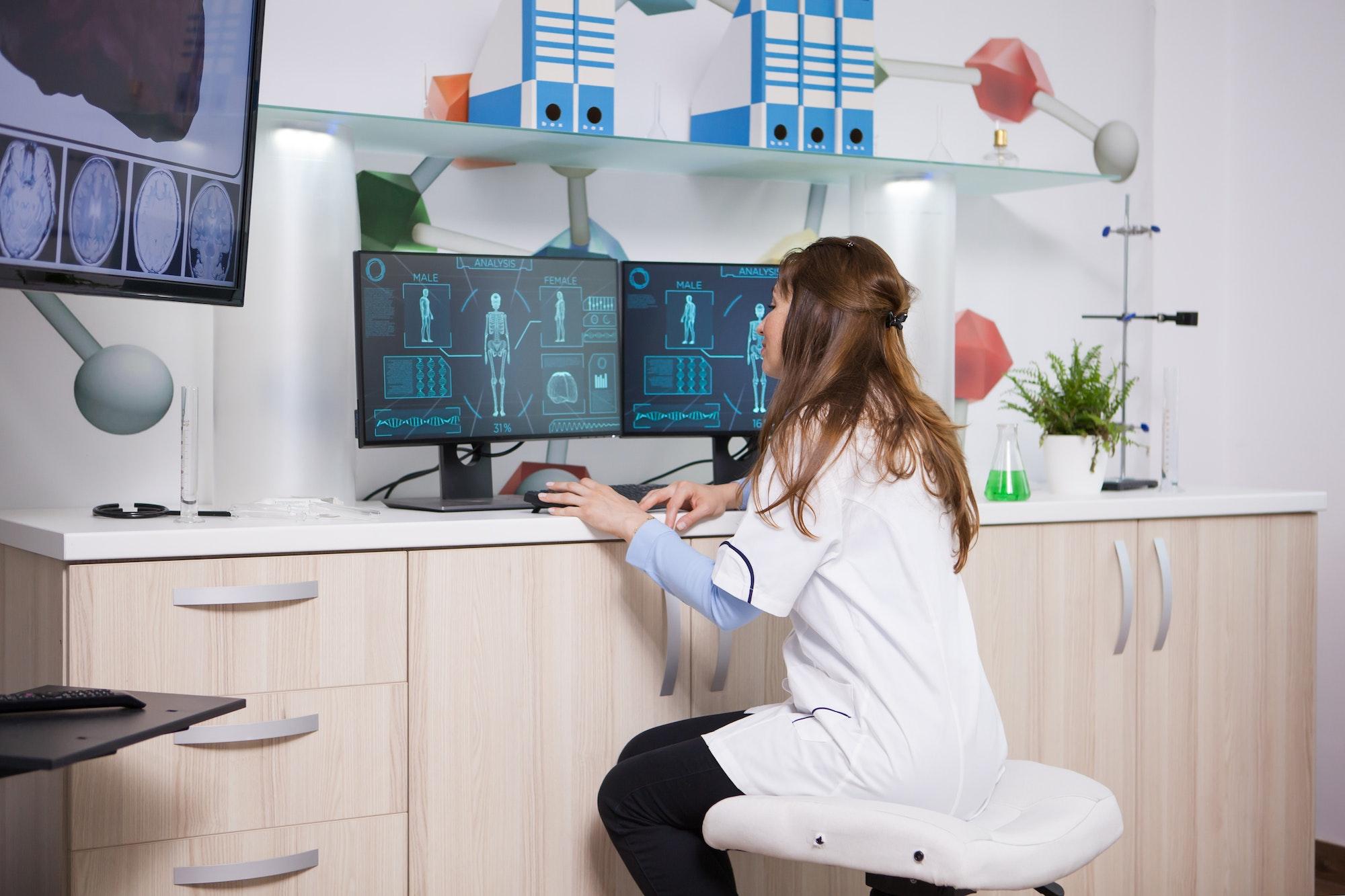 Female genetic scientist checking how food changes human body on computer in a laboratory