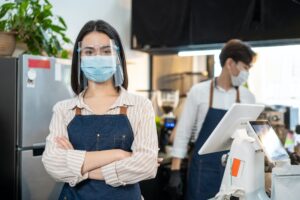 Portrait of attractive Caucasian waitress wearing protective mask to prevent from Covid-19