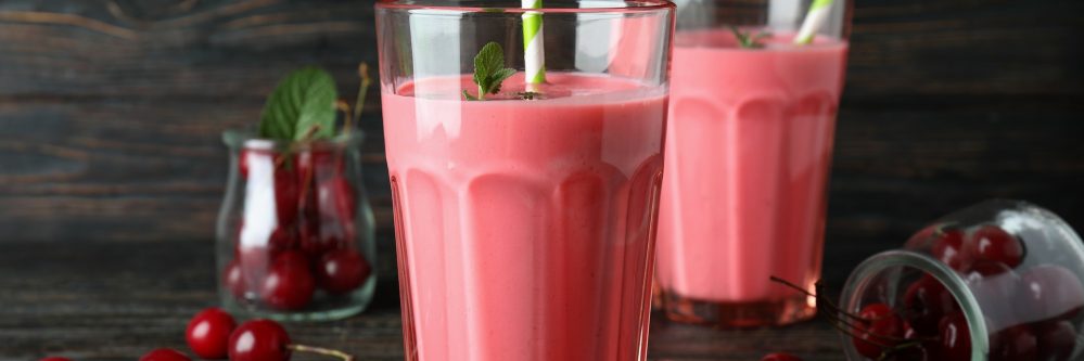 Cherry smoothie and ingredients on rustic wooden table